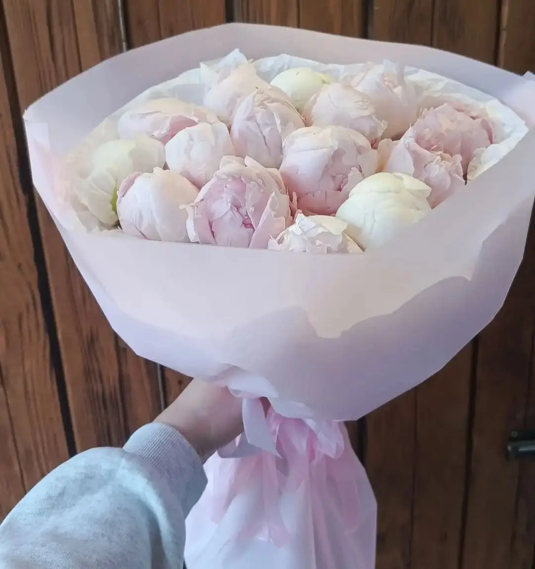 Букет из пионов в нежно-розовой упаковке.